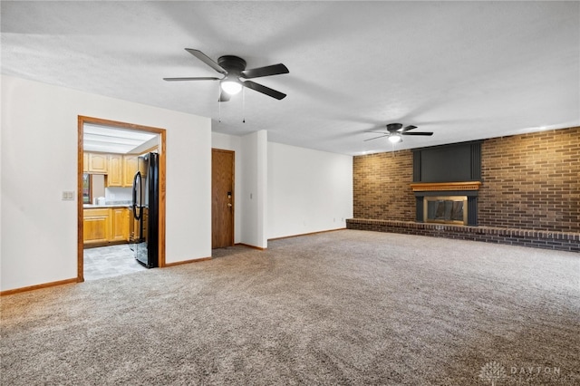 unfurnished living room with ceiling fan, light colored carpet, and brick wall