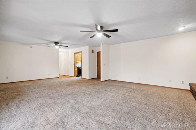 empty room with a textured ceiling, light colored carpet, and ceiling fan