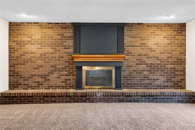 room details featuring a textured ceiling, carpet floors, and a brick fireplace