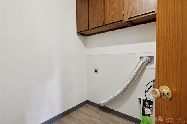 laundry area featuring hookup for an electric dryer, cabinets, and light wood-type flooring