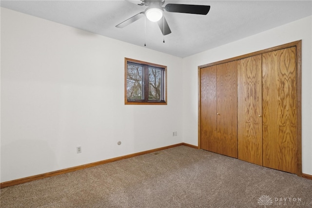 unfurnished bedroom featuring ceiling fan, a closet, and light colored carpet