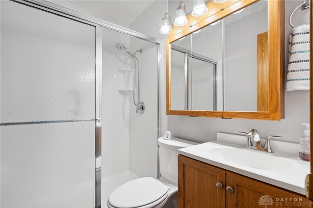 bathroom featuring toilet, vanity, and walk in shower