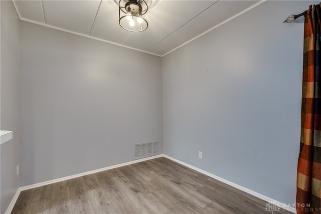 spare room with light wood-type flooring and ornamental molding