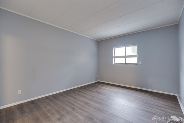 empty room featuring crown molding and hardwood / wood-style flooring