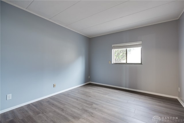 spare room featuring light hardwood / wood-style floors and ornamental molding