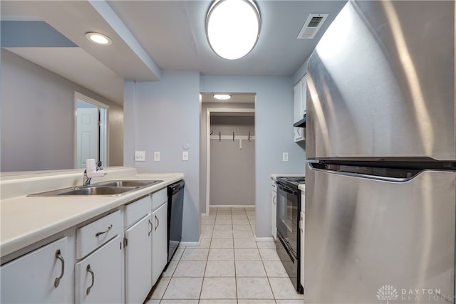 kitchen featuring white cabinetry, sink, light tile patterned floors, and stainless steel appliances