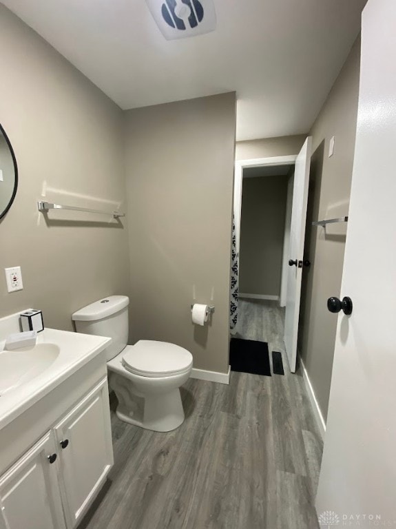 bathroom with hardwood / wood-style floors, vanity, and toilet