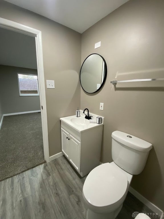 bathroom featuring vanity, hardwood / wood-style flooring, and toilet