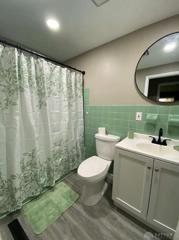 bathroom featuring toilet, vanity, tile walls, and hardwood / wood-style flooring