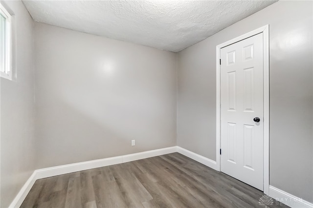 spare room with a textured ceiling and hardwood / wood-style flooring