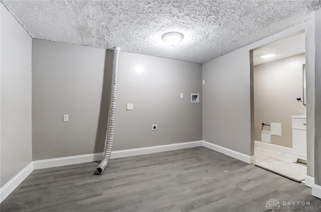 laundry room featuring hardwood / wood-style flooring, electric dryer hookup, a textured ceiling, and washer hookup