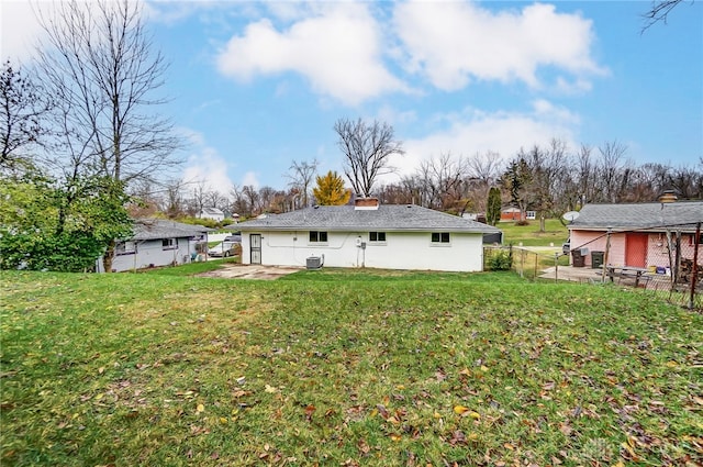 rear view of house featuring a yard, a patio, and central AC