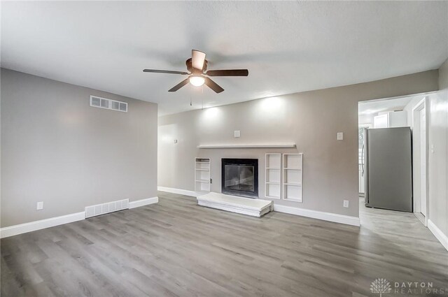 unfurnished living room with hardwood / wood-style flooring and ceiling fan