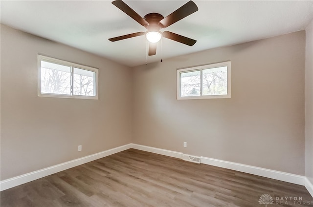 unfurnished room featuring hardwood / wood-style flooring, ceiling fan, and a healthy amount of sunlight