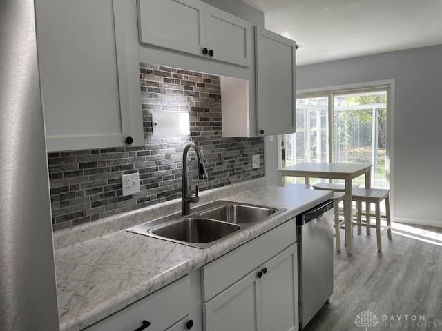 kitchen with white cabinetry, dishwasher, tasteful backsplash, and sink