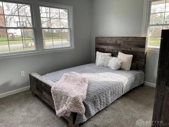 bedroom with light colored carpet and multiple windows