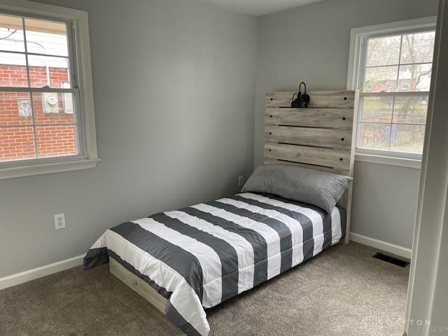 carpeted bedroom featuring multiple windows