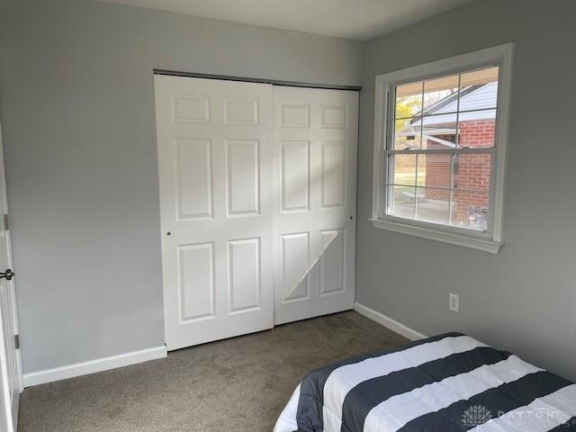 bedroom featuring dark carpet and a closet