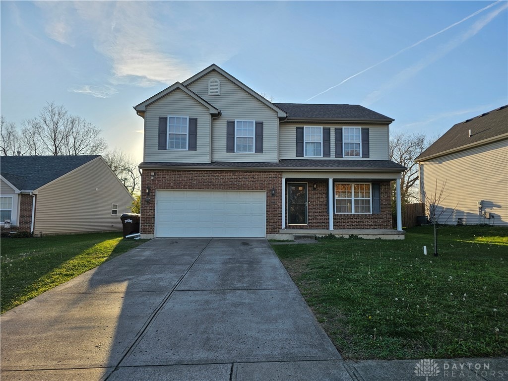 view of front property featuring a garage, a porch, and a front lawn