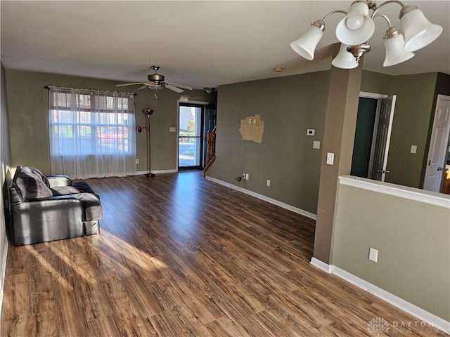 unfurnished living room featuring dark wood-type flooring and ceiling fan