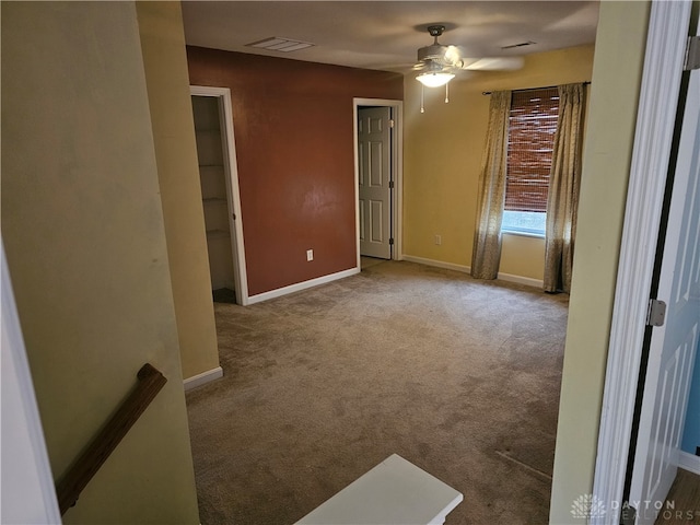 empty room featuring ceiling fan and light carpet