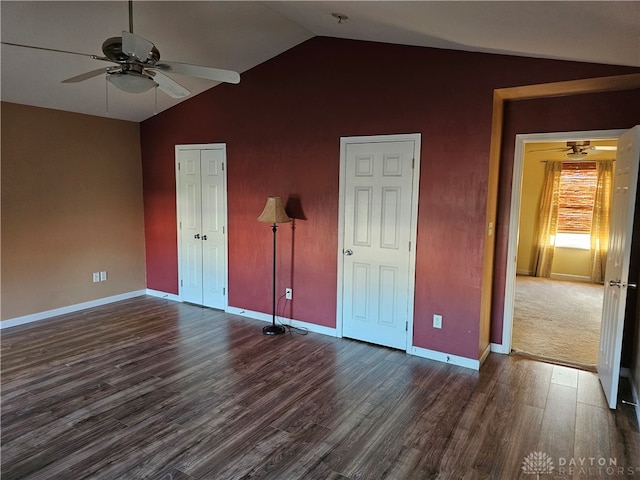 unfurnished bedroom featuring dark hardwood / wood-style flooring, vaulted ceiling, and ceiling fan