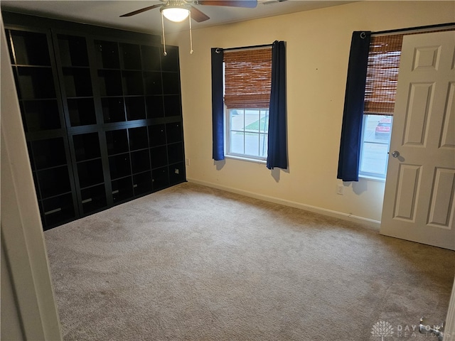 empty room with ceiling fan and carpet