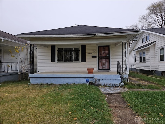 bungalow with a front lawn and covered porch