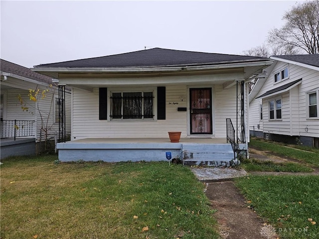 bungalow featuring a porch and a front lawn