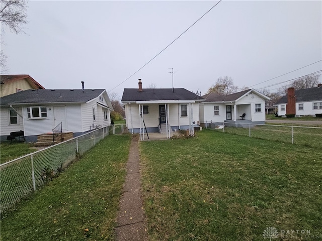 rear view of property with a wall mounted AC and a lawn