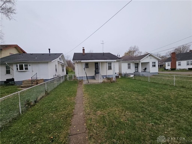 rear view of property with a wall mounted AC, a patio area, and a lawn