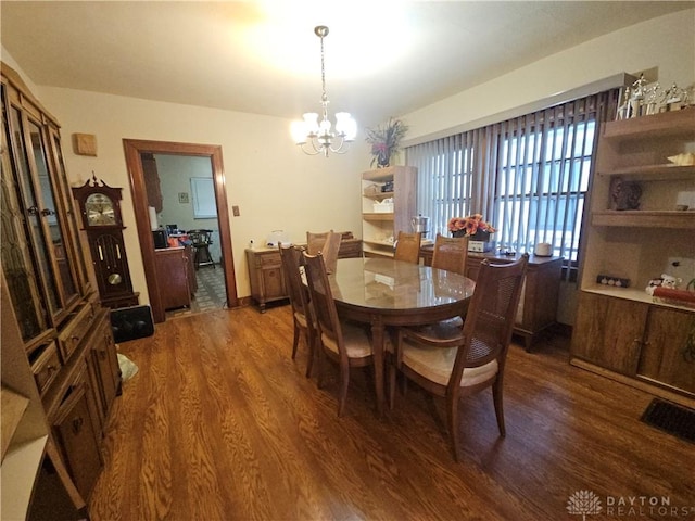 dining area with a notable chandelier and dark hardwood / wood-style flooring