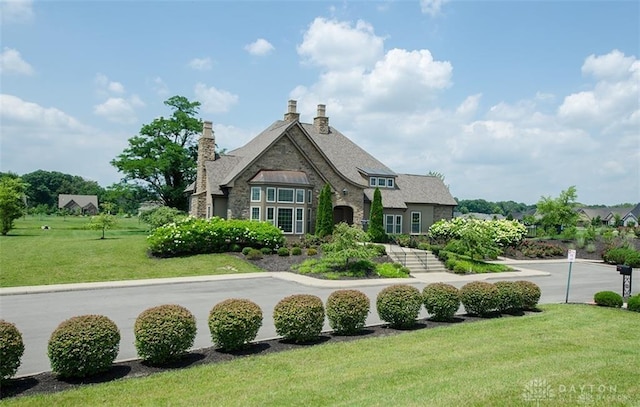 9333 Rochelle Ln, Clearcreek Twp, OH 45458 - rear view of property featuring stone siding, a lawn, and a chimney