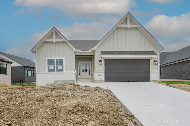 9333 Rochelle Ln, Clearcreek Twp, OH 45458 - view of front of home with board and batten siding, a garage, brick siding, concrete driveway, and roof with shingles