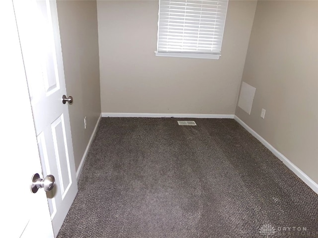 unfurnished room with dark colored carpet