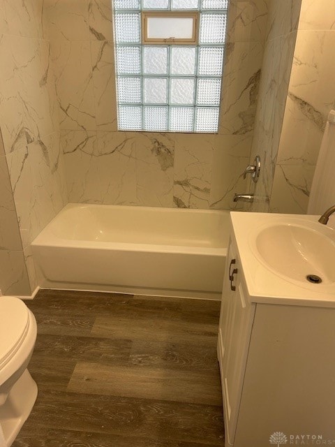 full bathroom with shower / washtub combination, vanity, wood-type flooring, and toilet