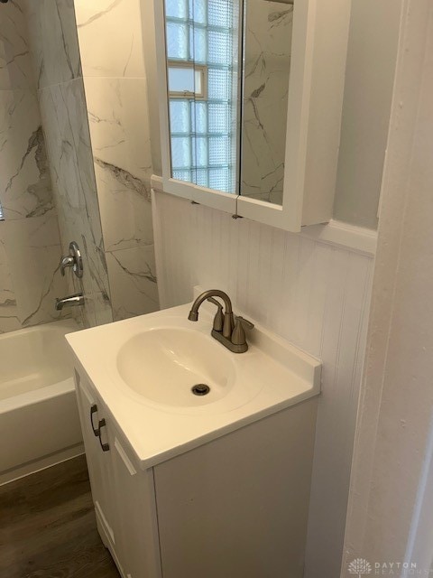 bathroom with vanity, hardwood / wood-style floors, and tiled shower / bath combo