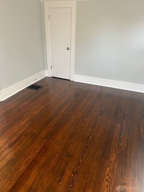 empty room with dark wood-type flooring