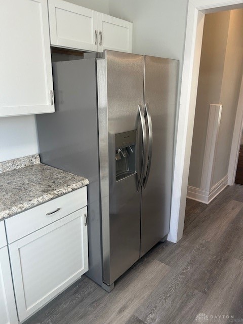 kitchen with white cabinets, stainless steel refrigerator with ice dispenser, dark hardwood / wood-style flooring, and light stone countertops