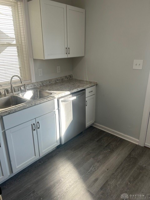 kitchen with stainless steel dishwasher, white cabinetry, dark wood-type flooring, and sink