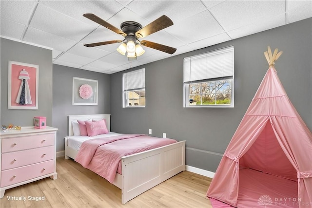 bedroom with a paneled ceiling, ceiling fan, and light hardwood / wood-style flooring