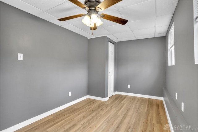 unfurnished room featuring a paneled ceiling, ceiling fan, and light hardwood / wood-style flooring