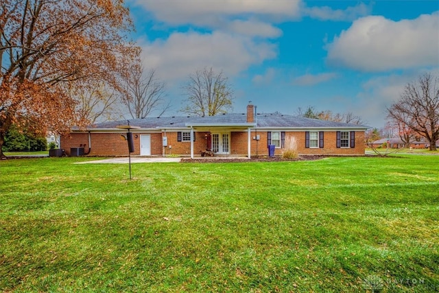 rear view of house with a yard and cooling unit