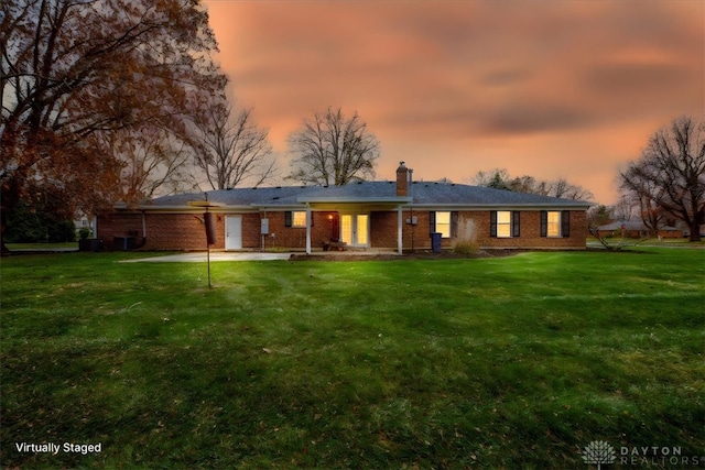 ranch-style home featuring a yard