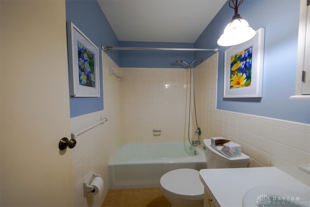 full bathroom with vanity, toilet, tile walls, and tiled shower / bath