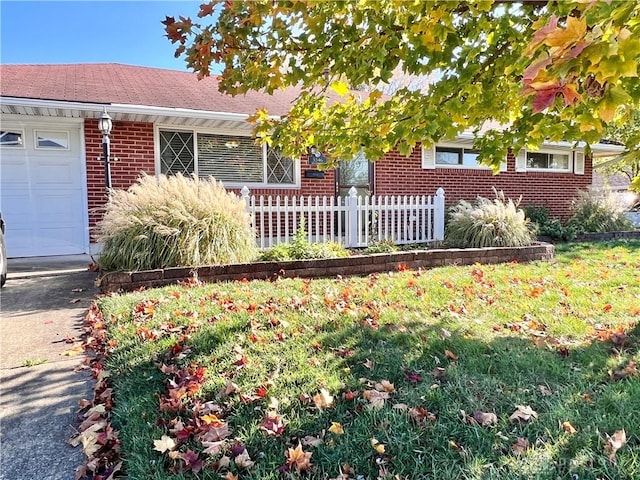 ranch-style house with a garage and a front lawn