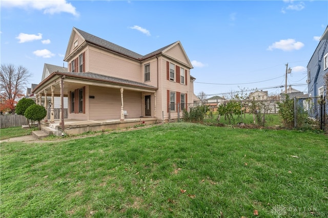 rear view of property featuring a porch and a yard