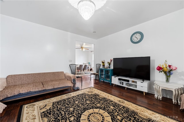 living room featuring ceiling fan with notable chandelier and hardwood / wood-style flooring