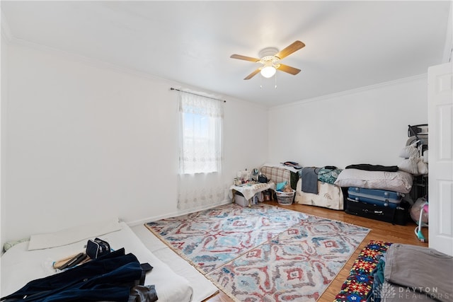 bedroom with wood-type flooring, ceiling fan, and ornamental molding