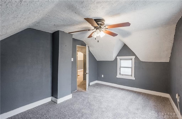 additional living space with carpet, ceiling fan, lofted ceiling, and a textured ceiling